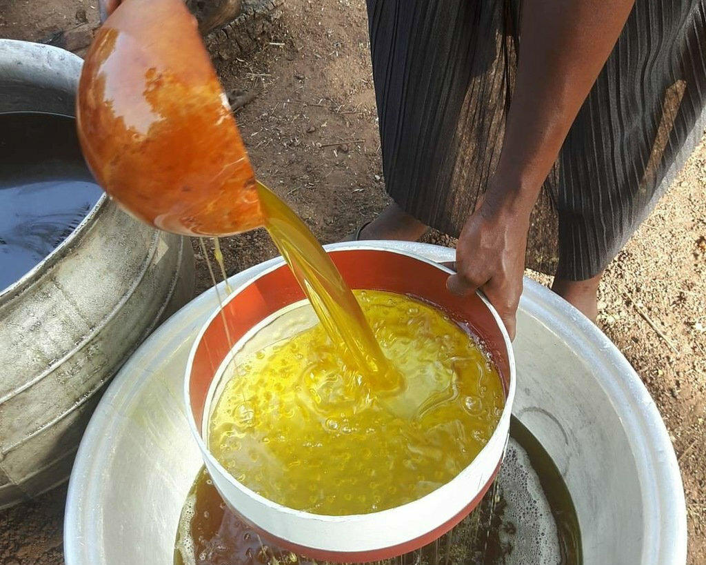 Melted shea butter being filtered to remove impurities and ensure a high-quality product.